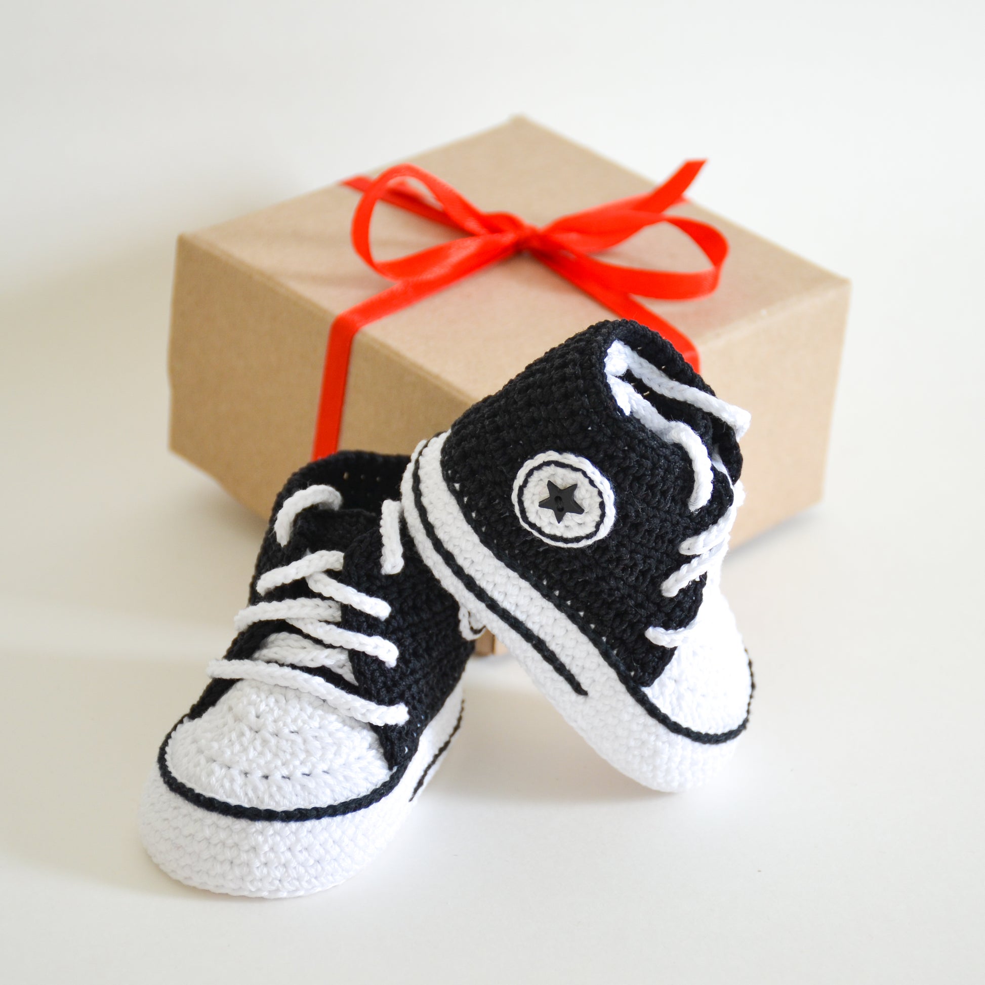 Handmade baby boy sneakers crochet pattern – Classic black and white baby shoes with gift-ready packaging.