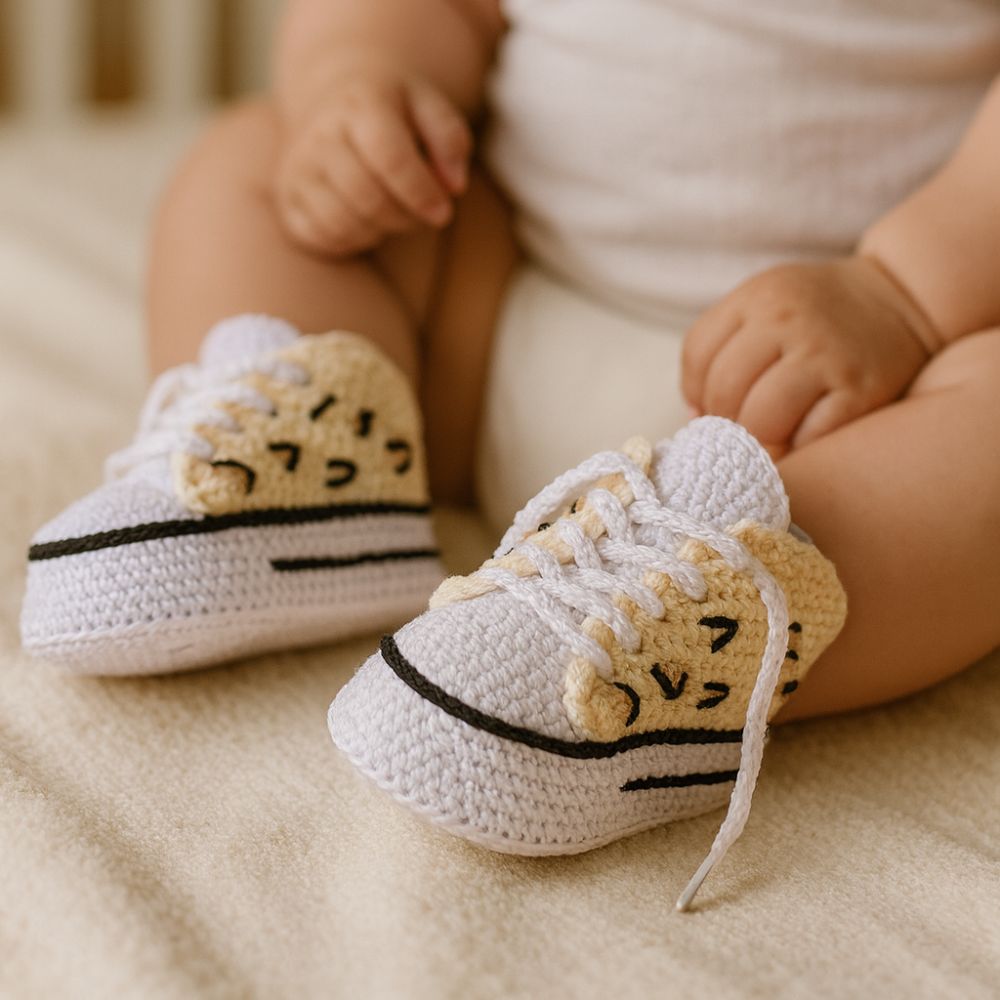 Baby wearing handmade crochet leopard sneakers – crochet pattern for newborn shoes