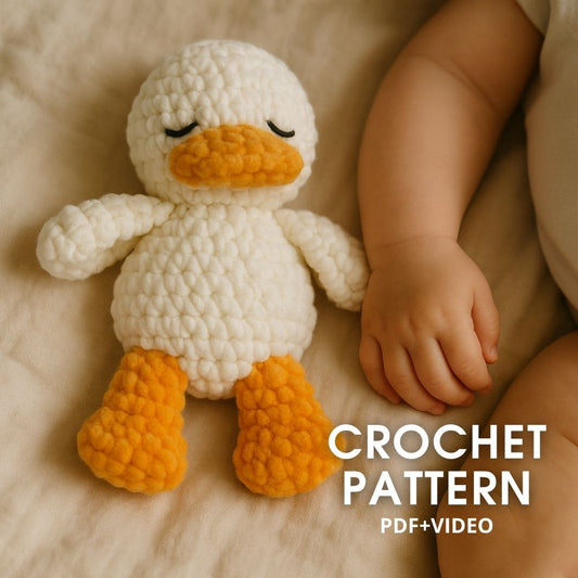 Plush crochet duck toy lying next to baby – digital amigurumi pattern PDF and video tutorial