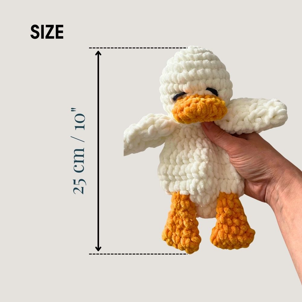 Hand holding 10 inch crochet duck – soft amigurumi lovey size reference