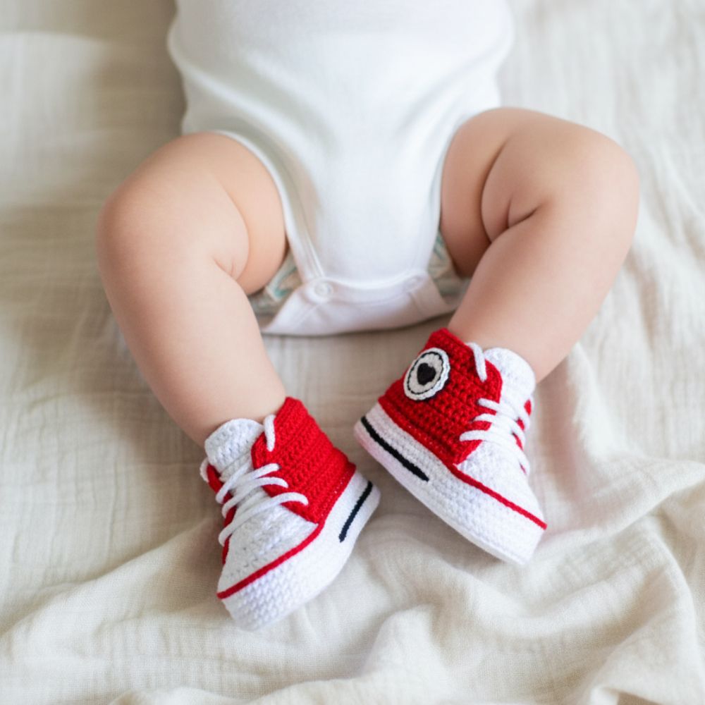 Crochet baby sneakers pattern shown on newborn feet