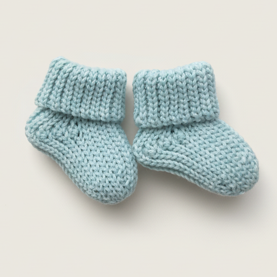 Soft blue ribbed crochet baby socks made with warm worsted-weight yarn
